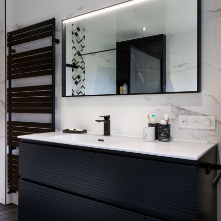 Rénovation salle de bain moderne avec douche, baignoire et carrelage effet marbre noir