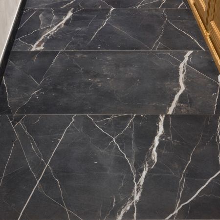 Pose de carrelage effet marbre noir dans un dégagement intérieur
