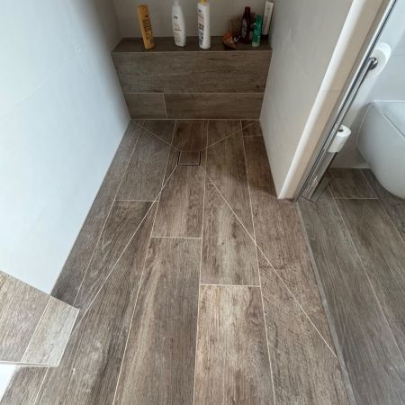 Aménagement d’un espace douche sous pente avec carrelage effet bois