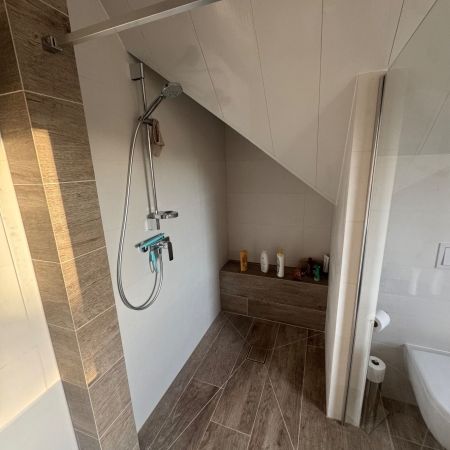 Aménagement d’un espace douche sous pente avec carrelage effet bois
