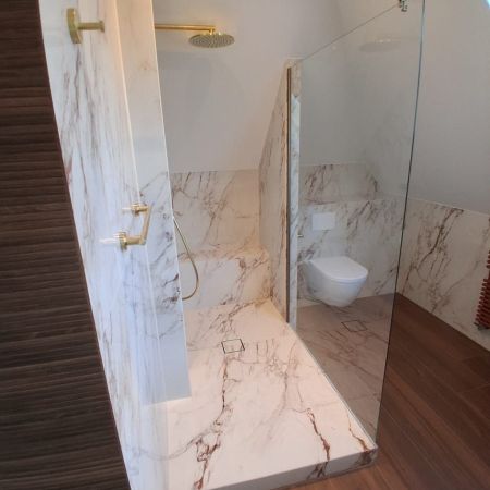 Une salle de bains sous combles élégante entre effet marbre et imitation bois