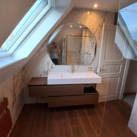 Une salle de bains sous combles élégante entre effet marbre et imitation bois