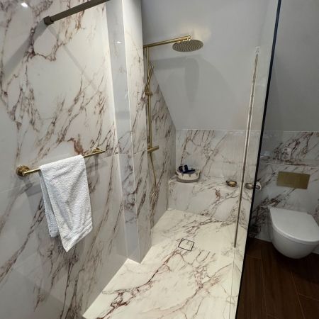 Une salle de bains sous combles élégante entre effet marbre et imitation bois