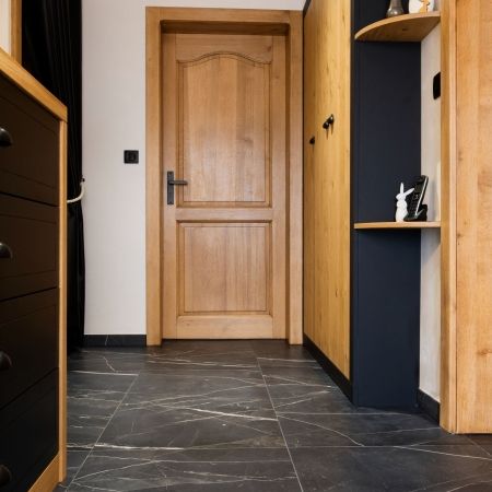 Pose de carrelage effet marbre noir dans un dégagement intérieur