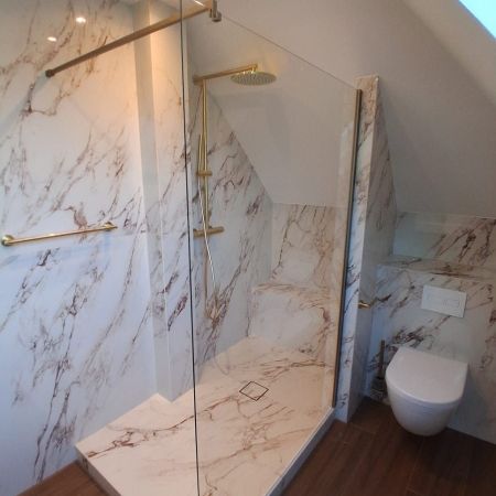 Une salle de bains sous combles élégante entre effet marbre et imitation bois