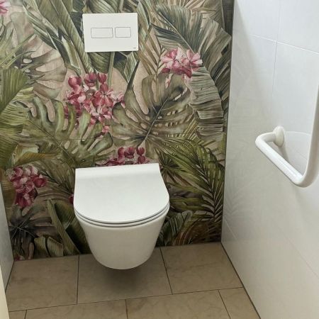 Rénovation de toilette PMR avec WC suspendu et carrelage décoratif tropical Rénovation de toilette PMR avec WC suspendu et carrelage décoratif tropical